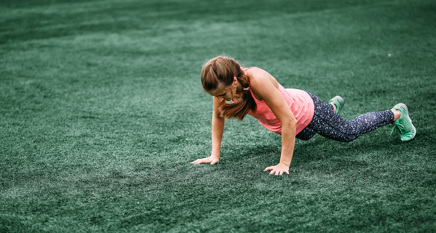 Woman doing burpees in field